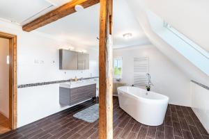 a bathroom with a white tub and a sink at Ferienhaus St Georg Stube in Grömbach +37 photos