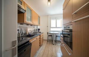 a kitchen with wooden cabinets and a sink and a table at Belfort Break in Chalon-sur-Saône +9 photos