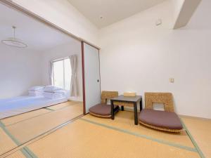Zimmer mit einem Tisch, 2 Stühlen und einem Bett in der Unterkunft 友縁の家Destined Bonds Haven西巣鴨 in Tokio