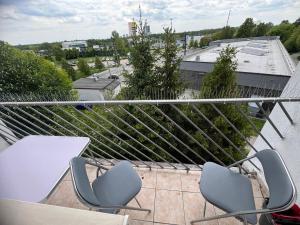 a balcony with two chairs and tables on a roof at Mieszkaj u Marty stale na Stałym in Jaworzno