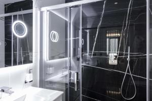 ein Badezimmer mit Dusche, Waschbecken und Spiegel in der Unterkunft Un acogedor complejo compuesto de 5 apartamentos in Barbate + 42 Fotos