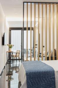 ein Schlafzimmer mit einem Bett und einem Tisch mit Stühlen in der Unterkunft Un acogedor complejo compuesto de 5 apartamentos in Barbate