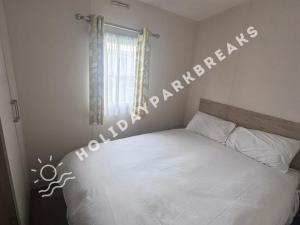 a bedroom with a bed with a sign on the wall at 3 bedroom Static Home by White Horse, Seal Bay in Selsey +12 photos