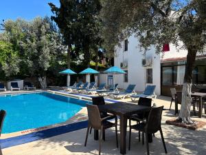 a patio with a table and chairs next to a pool at Ali Baba Hotel Gümbet in Gümbet