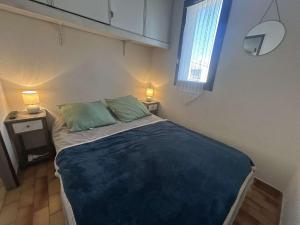 a bedroom with a bed with two pillows and a window at Appartement une chambre CAP D'AGDE CT950-206 in Cap d'Agde