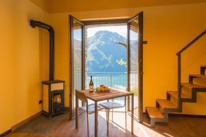 a dining room with a table and a fireplace at Tra Lago e Montagna Baita la Morena in Nesso