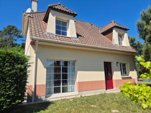 une maison avec une porte rouge et un toit dans l'établissement Les sables, à Le Touquet-Paris-Plage