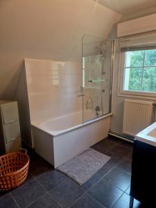 une salle de bain avec baignoire et douche en verre dans l'établissement Les sables, à Le Touquet-Paris-Plage