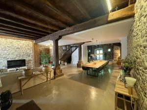 a large living room with a table and a stone wall at Casa APEZTEGUIA in Narvarte
