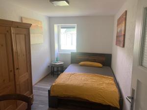 a bedroom with a bed with a yellow bedspread at Tarahaus in Sankt Georgen im Schwarzwald