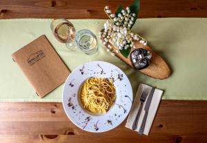 a plate of spaghetti on a table with a glass of wine at Hotel Liptov in Belá