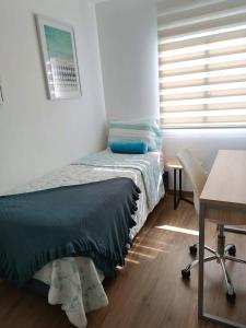 a bedroom with a bed and a desk and a window at Vive y trabaja con estilo en San Miguel, moderno departamento de 2 dorms con balcon in Lima