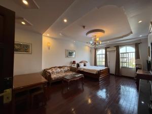 a living room with a bed and a couch at Hoa Phat Hotel & Apartment in Ho Chi Minh City +105 photos