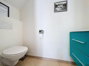 a bathroom with a toilet and a blue cabinet at ons kotje in De Panne +23 photos
