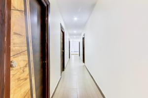 a hallway with white walls and a wooden door at Hotel O Moon Star in Maula Ali