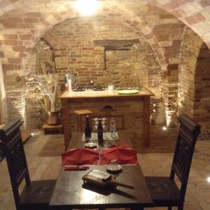 cocina con mesa y pared de piedra en Pantorano rooms, en Spinetoli
