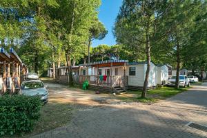 a house with a car parked in front of it at Albatross Mobile Homes on Camping Laguna Village in Porto Falconera