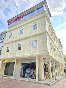 a large white building with a store front at Vaikuntha Stays Hotel in Indore