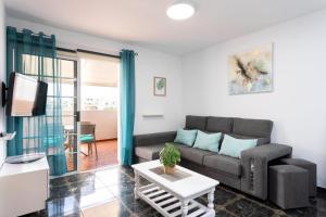 a living room with a couch and a table at Ático San Juan Teide View in Playa de San Juan