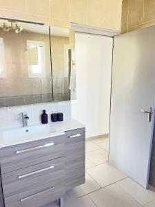 a bathroom with a sink and a mirror at Maison Champ du Fort, jardin et parking privé in Chablis +14 photos