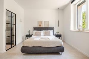 a bedroom with a large bed in a white room at IVY - Royal in Latina