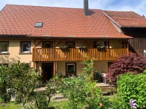 a house with a red roof and a wooden deck at Tarahaus in Sankt Georgen im Schwarzwald