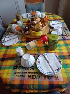 a table with a plate of food on a colorful table cloth at Aline et Dim in Méréville +3 photos