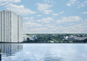 Blick auf ein Gebäude und einen großen Wasserkörper in der Unterkunft Urban Chic Studio at Amor Apartment in Pakuwon City Mall, East Surabaya by Le Ciel Hospitality in Surabaya