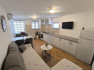a living room with a couch and a kitchen at Apartman Vukalović in Trebinje