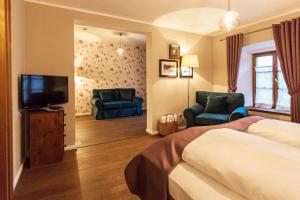 a hotel room with a bed and two chairs and a television at Landgasthof Karner in Frasdorf