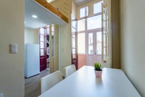 ein Esszimmer mit Tisch und Kühlschrank in der Unterkunft Close to Everything Your Oporto Terrace PRM 1T in Porto