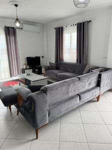 a living room with a large couch in the middle at Sea La View Apartment Saranda in Sarandë +30 photos