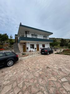 two cars parked in front of a house at Sea La View Apartment Saranda in Sarandë