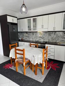 a kitchen with a table and chairs and a refrigerator at Sea La View Apartment Saranda in Sarandë