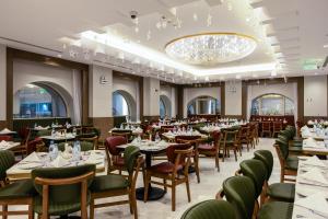 a dining room with tables and chairs and a chandelier at MADEN Al Rawda مادن الروضة in Medina
