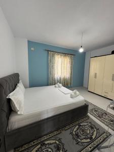 a bedroom with a bed and a blue wall at Sea La View Apartment Saranda in Sarandë