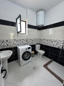a bathroom with a washing machine and a toilet at Sea La View Apartment Saranda in Sarandë