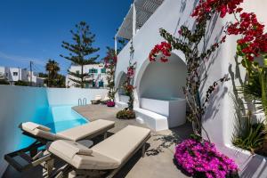 a patio with flowers and a swimming pool at Nissia Beach Apartments & Suites in Kamari