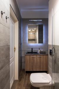 a bathroom with a toilet and a sink and a mirror at Prestigious Main Square Apartment in Kraków