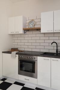 a kitchen with white cabinets and a stove at Prestigious Main Square Apartment in Kraków +8 photos