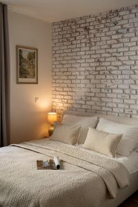 a bedroom with a brick wall and a bed at Prestigious Main Square Apartment in Kraków