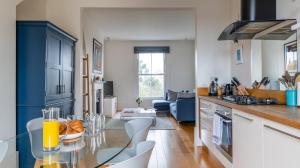 a kitchen and living room with a glass table at Channel View Apartments in Deal