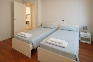 two twin beds in a room with a mirror at Apartamento de 2 habitaciones en la zona centro. in Castro-Urdiales