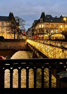 Un puente decorado con luces navideñas junto a un río. en La Savoureuse, en Belfort