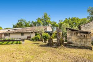 an old house with a stone building in a yard at Bienvenue à zot in Petit-Palais-et-Cornemps