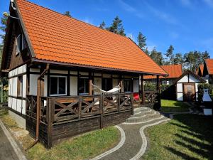 a small house with an orange roof and a fence at Sielska Chata Na Gwizdówce in Załakowo