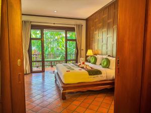 a bedroom with a bed and a door to a balcony at Baan Thai Lanta Resort in Ko Lanta +250 photos