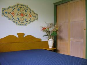 a bedroom with a bed and a vase with flowers at Alessidamo Club Metaponto in Metaponto +24 photos