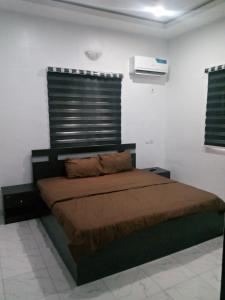 AroにあるFolly bee apartment & suitesの白い壁のベッドルーム1室