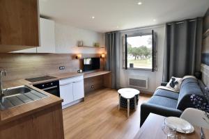 une cuisine et un salon avec un canapé et une table dans l'établissement Tom 01 - 5min à pied de la Plage, à Fréhel